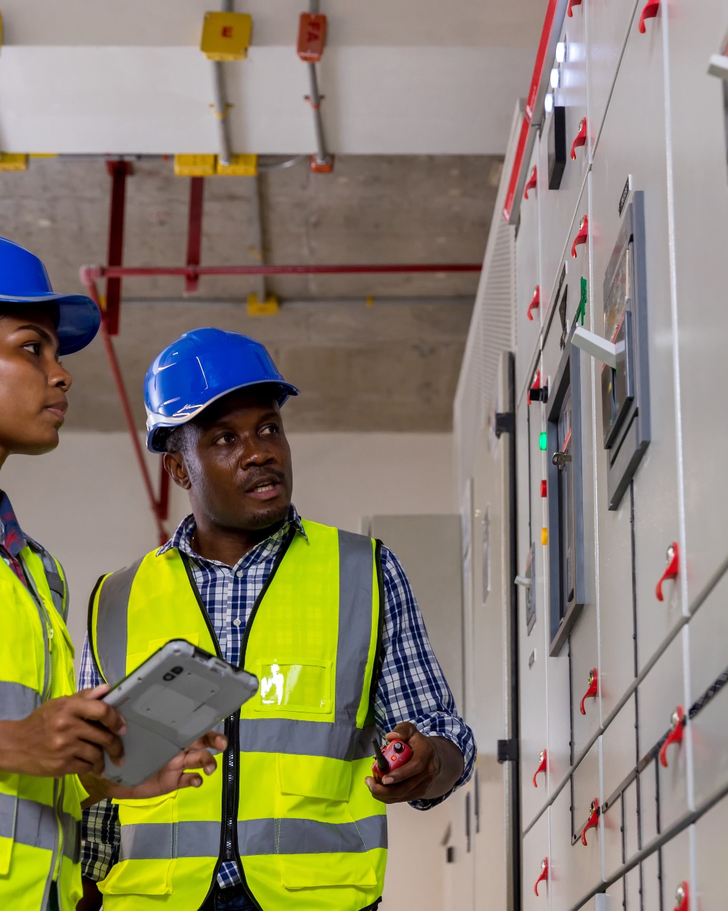 Electrical engineers reviewing power distribution panels on site